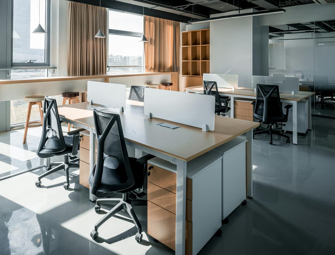 An office with a desk, chairs and a window