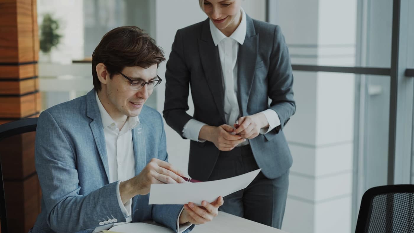 Two people discussing an invoice across a desk