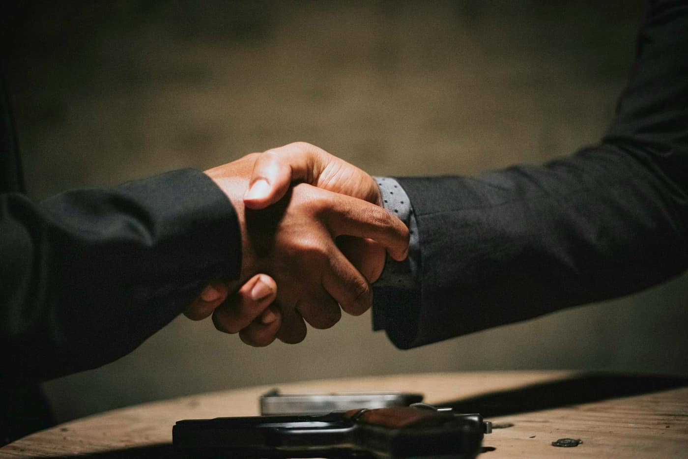 A handshake over a desk agreeing a deposit