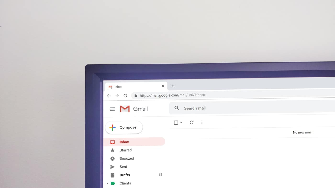 A laptop showing an email inbox on a desk