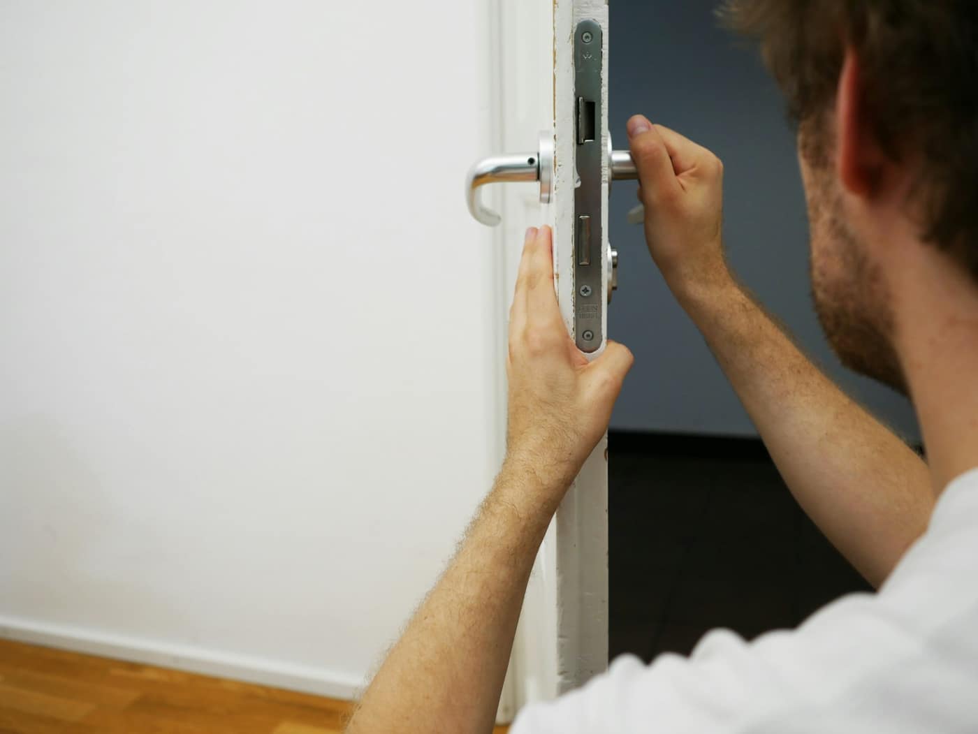 A hand on a door lock and handle