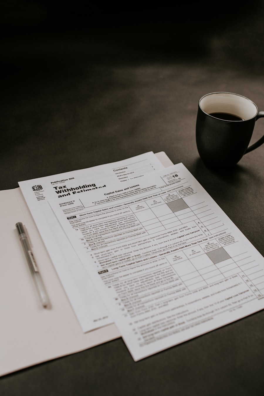 Office paperwork with a black ceramic mug on the desk