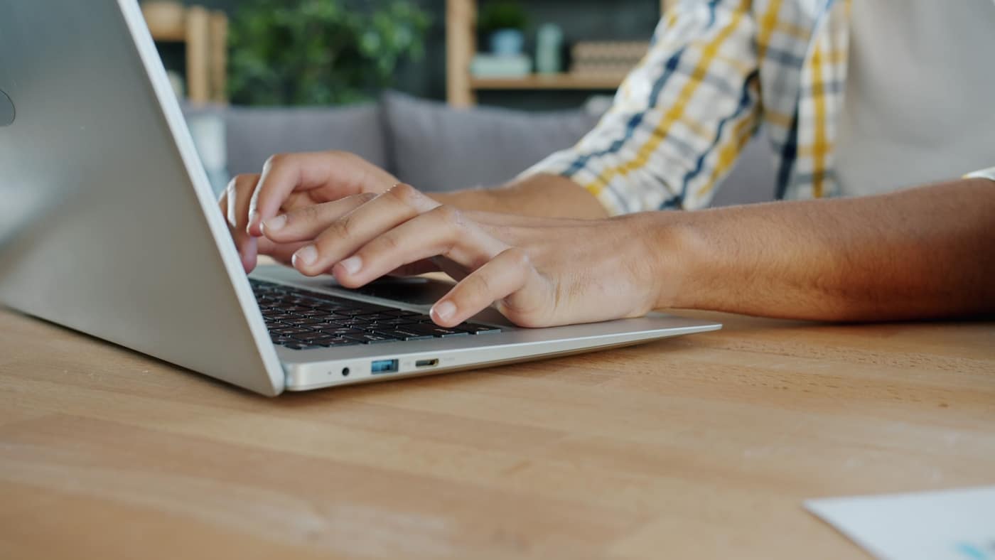 A person typing an email on a laptop