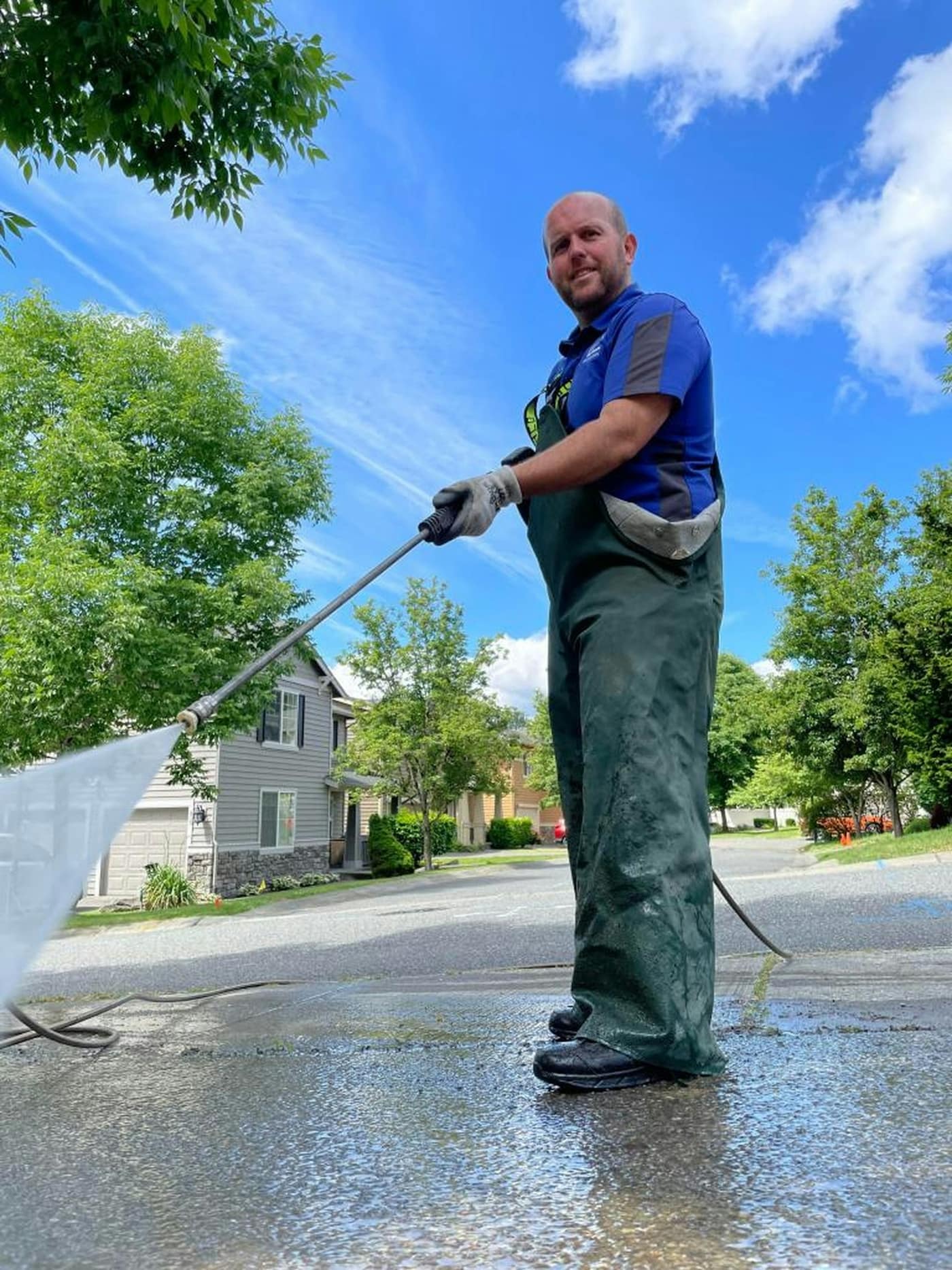 A pressure washer cleaning a paved surface