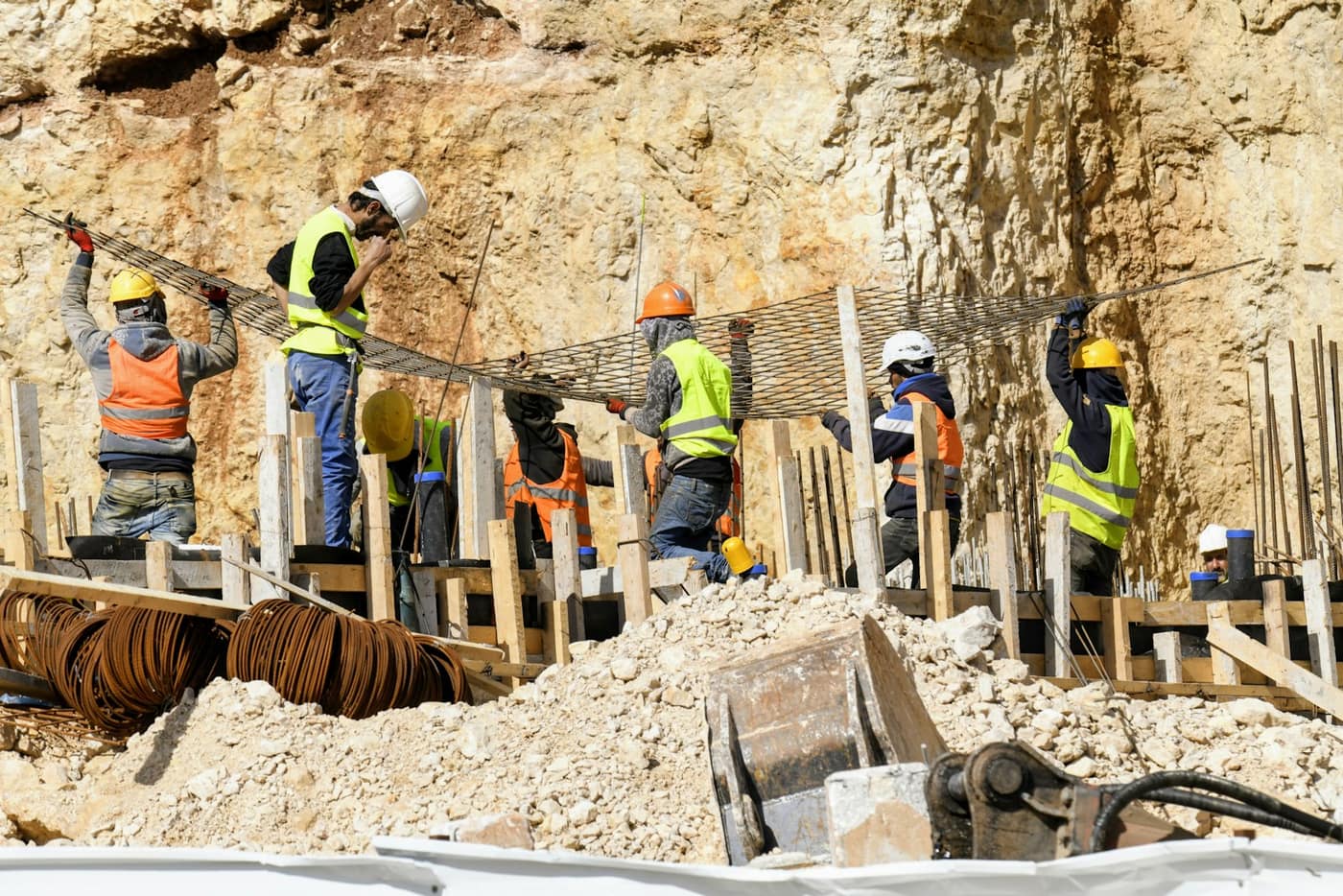 A crew fixing steel reinforcement into formwork, a stage that would be claimed on a progress invoice