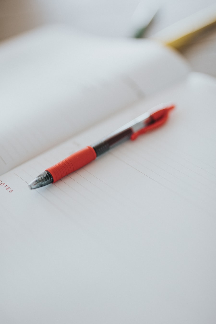 A red pen resting on a clean paper