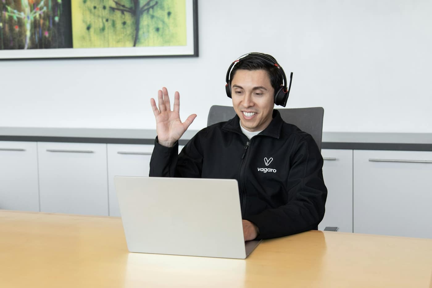 A headset and laptop on a home-office desk