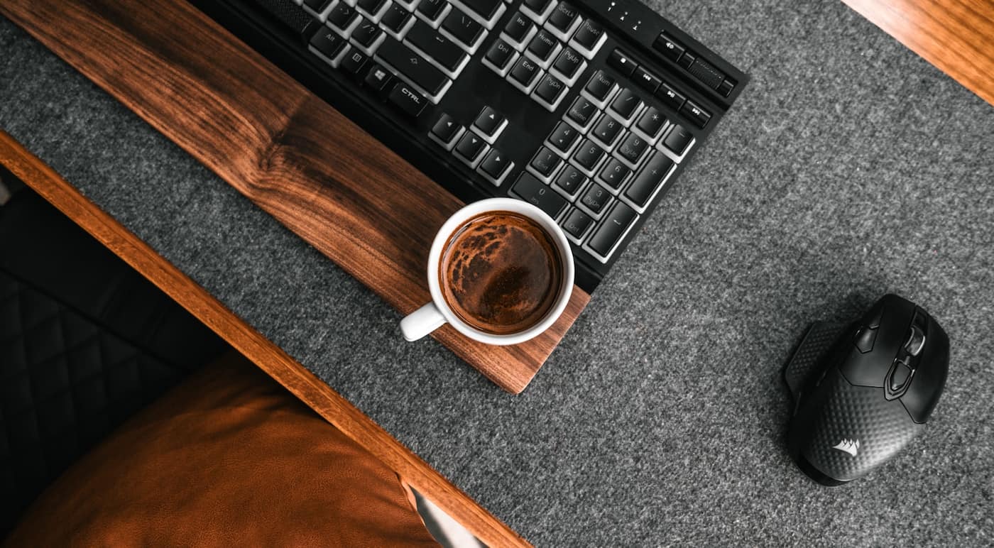 A cup of coffee next to a keyboard