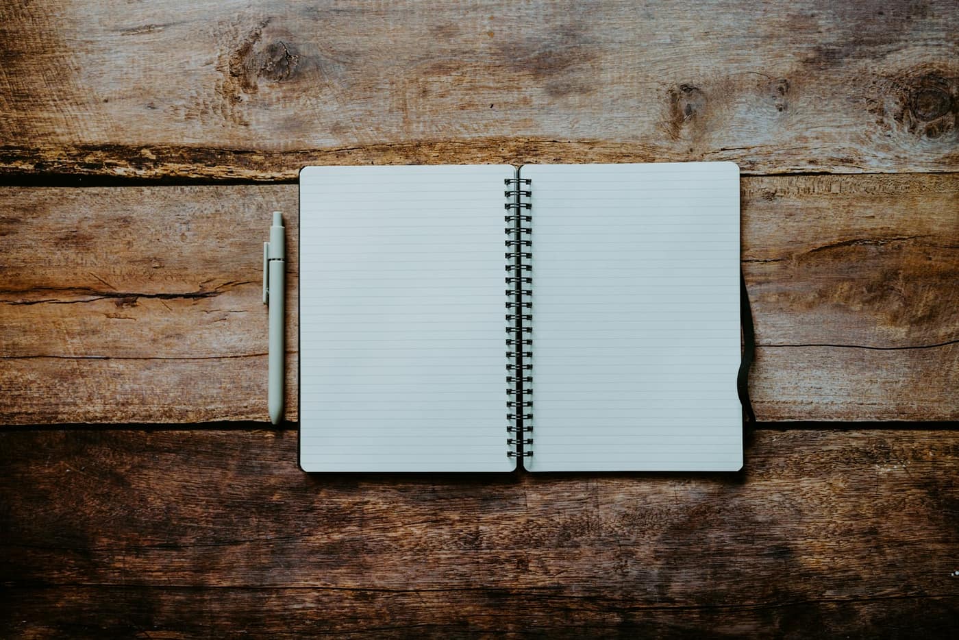 A notebook and pen on a wooden table